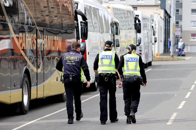 Police officers speak to a member of the security team ahead of the Scottish Cup semi final match at Hampden Park, Glasgow. Picture date: Sunday April 17, 2022.