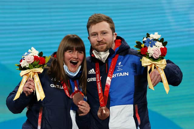 BEIJING, CHINA - MARCH 05: Bronze Medallists Millie Knight and their guide Brett Wild celebrate with their medals during the Para Alpine Skiing Women's Downhill Vision Impaired Medal Ceremony during Day One of the Beijing 2022 Winter Paralympics at Yanqing Para Medals Plaza on March 05, 2022 in Yanqing, China. (Photo by Alexander Hassenstein/Getty Images)