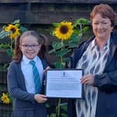 Rona Mackay MSP presents Thea (10) with a special certificate from the Scottish Parliament for her fundraising work