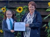 Rona Mackay MSP presents Thea (10) with a special certificate from the Scottish Parliament for her fundraising work