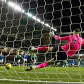 Hibs goalkeeper Matt Macey is beaten by Kemar Roofe's penalty for the only goal of the game
