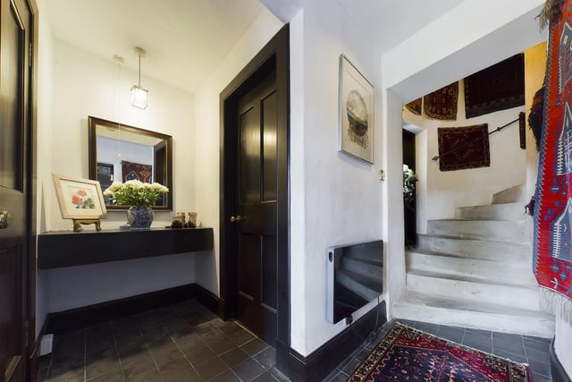 Visitors are welcomed in to the entrance hallway with tiled floor and large storage cupboard.