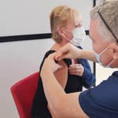 Dr Gregory Bowes (Dentist) giving vaccination to Elaine Austin. NHSL_Ravenscraig_vaccination_centre_2021