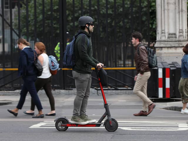 A person riding an electric scooter in Westminster, London.