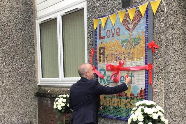Joe McCaig from East Renfrewshire Council unveils the mosaic