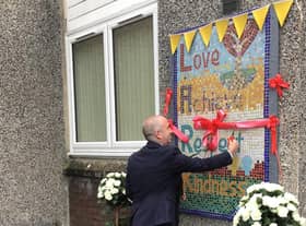 Joe McCaig from East Renfrewshire Council unveils the mosaic