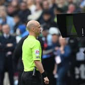 Referee Anthony Taylor looks at the VAR screen during a Premier League match between West Ham United and Manchester City. (Photo by JUSTIN TALLIS/AFP via Getty Images)