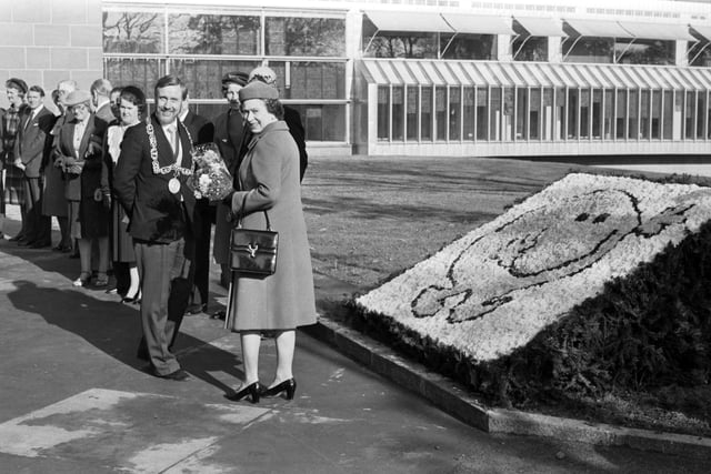 Queen Elizabeth II, escorted by Lord Provost Dr Michael Kelly, officially opened the Burrell Museum, built in Pollok Country Park Glasgow to house the Burrell Collection, in October 1983. The Queen and Provost Kelly walk past the 'Glasgow Smiles Better' smiley face logo.