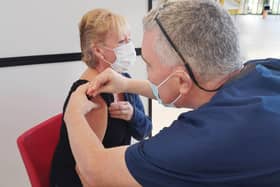 Dr Gregory Bowes (Dentist) giving vaccination to Elaine Austin. NHSL_Ravenscraig_vaccination_centre_2021