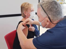 Dr Gregory Bowes (Dentist) giving vaccination to Elaine Austin. NHSL_Ravenscraig_vaccination_centre_2021