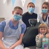 Gabriel Matthias Schoenhofen gives up a thumbs up after his treatment with (l-r) dentist James Dunaway, practice manager Courtney Forrester and nurse Louise Thomson