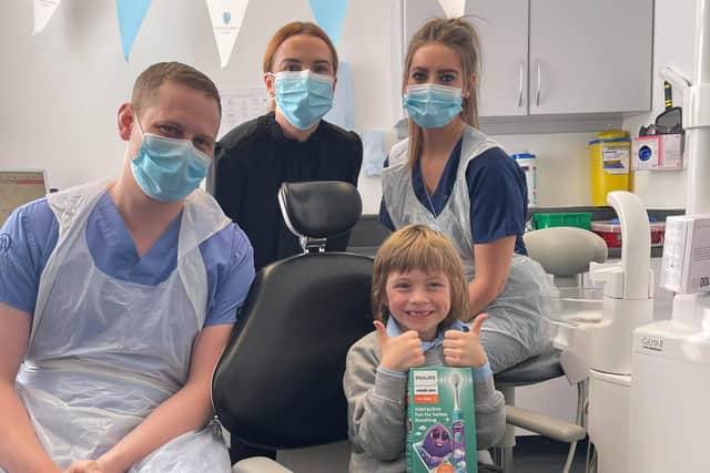 Gabriel Matthias Schoenhofen gives up a thumbs up after his treatment with (l-r) dentist James Dunaway, practice manager Courtney Forrester and nurse Louise Thomson