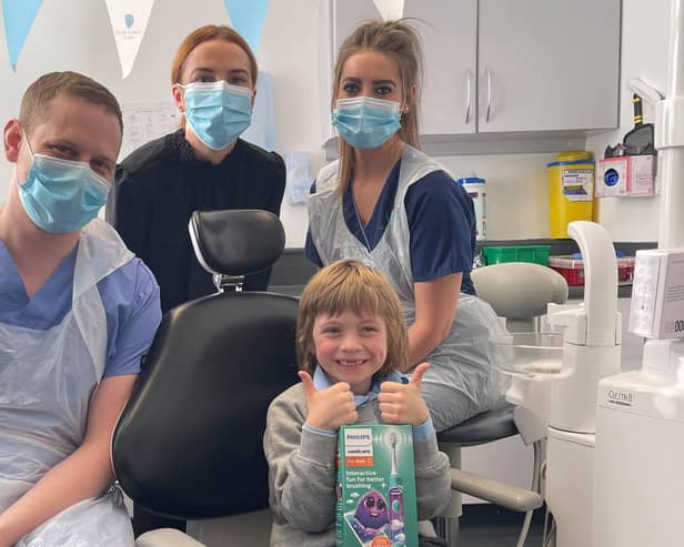 Gabriel Matthias Schoenhofen gives up a thumbs up after his treatment with (l-r) dentist James Dunaway, practice manager Courtney Forrester and nurse Louise Thomson