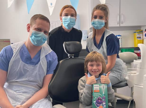 Gabriel Matthias Schoenhofen gives up a thumbs up after his treatment with (l-r) dentist James Dunaway, practice manager Courtney Forrester and nurse Louise Thomson