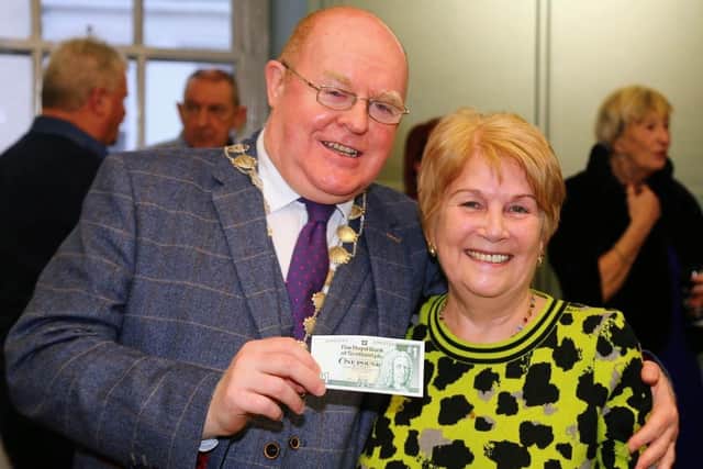 Eleanor McLean receives her £1 note from Andy Morrison.