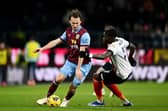 BURNLEY, ENGLAND - JANUARY 12: Hjalmar Ekdal of Burnley on with the ball whilst under pressure from Elijah Adebayo of Luton Town during the Premier League match between Burnley FC and Luton Town at Turf Moor on January 12, 2024 in Burnley, England. (Photo by Gareth Copley/Getty Images)