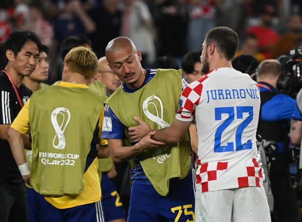 <p>Croatia's Josip Juranovic consoles Japan forward, and Celtic team-mate, Daizen Maeda after the World Cup last 16 clash. (Photo by ANDREJ ISAKOVIC/AFP via Getty Images)</p>