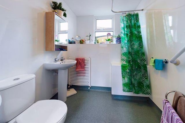 A tropical vibe is evident in the upstairs wet room, which  boasts an electric shower and white suite.