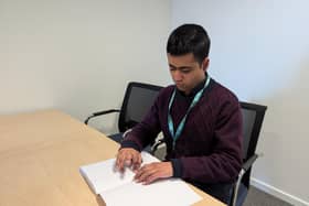 Bilal Iqbal reading braille at the Scottish Braille Press