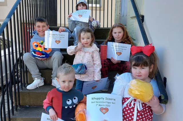 The winners of the online decorated ball competition last year assembled on the Tolbooth steps with their certificates.