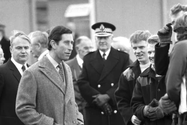 Prince Charles chats with workmen during a visit to the Easterhouse market garden project in Glasgow, December 1987.