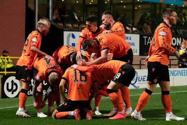 Dundee United's Aziz Behich is mobbed by his team-mates after scoring the opener against Hibs.