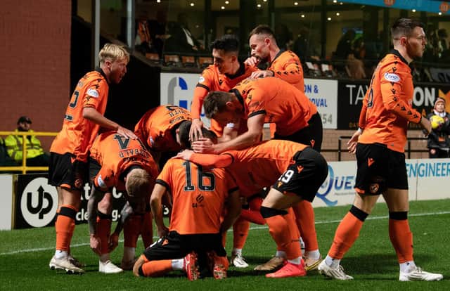 Dundee United's Aziz Behich is mobbed by his team-mates after scoring the opener against Hibs.