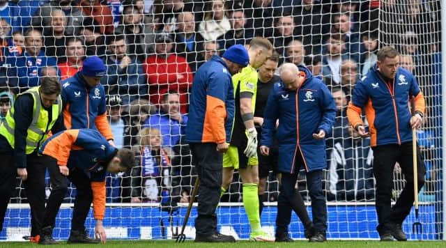 Rangers groundstaff with Celtic goalkeeper Joe Hart as they remove glass fragments from the penalty area before the start of the second half at Ibrox on Sunday.  (Photo by Rob Casey / SNS Group)