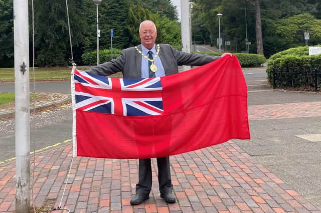 East Renfrewshire provost Jim Fletcher gets ready to fly the flag