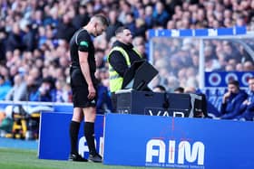 Referee David Dickinson checks VAR before awarding Rangers a penalty.