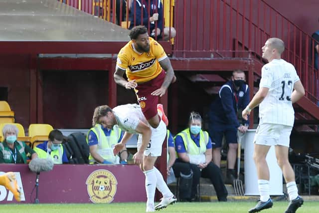 Kaiyne Woolery takes a tumble against Hibs defenders