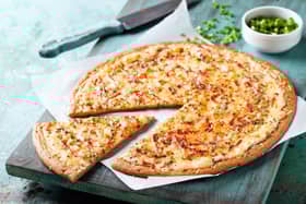 A gluten free pizza with bacon and spring onions.