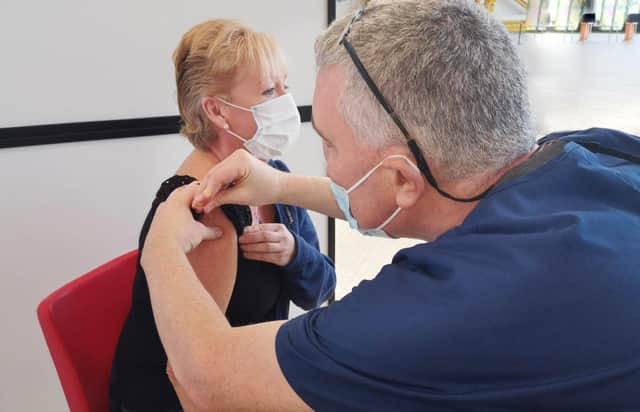 Dr Gregory Bowes (Dentist) giving vaccination to Elaine Austin. NHSL_Ravenscraig_vaccination_centre_2021