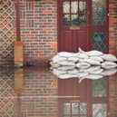 Sandbags outside front door of flooded house. Photo: Adobe