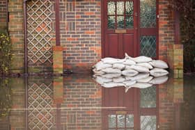 Sandbags outside front door of flooded house. Photo: Adobe