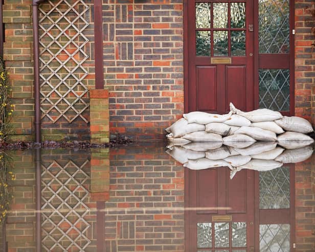 Sandbags outside front door of flooded house. Photo: Adobe