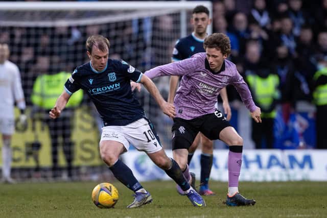 Dundee's Paul McGowan (L) and Rangers' Alex Lowry challenge for possession.