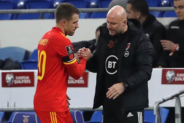 Wales' interim head coach Rob Page shakes hands with midfielder Aaron Ramsey. (Photo by GEOFF CADDICK/AFP via Getty Images)
