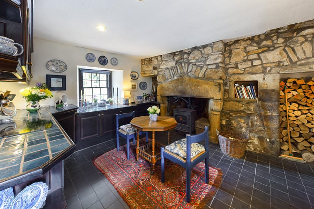 The kitchen boasts another log burning stove set within a large stone hearth.