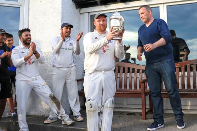 Bryan Clarke accepts the Premier Division trophy in 2019, the last year the league was contested (Pic by David Potter)