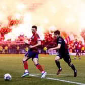 Rangers' Ryan Jack and Dundee's Owen Beck in action as flares fill the stand behind them.  (Photo by Ross Parker / SNS Group)