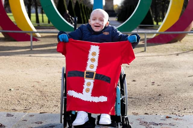 Cole shows off the design of the new reusable Santa Dash T-shirts ahead of the charity fun run.