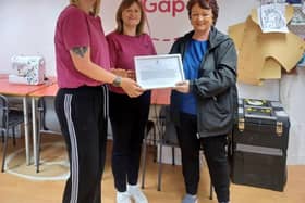 DELIGHTED: Amanda and Patricia, founders of Stitch the Gap, receive a framed motion from Rona Mackay MSP after their success at the EDGE Awards