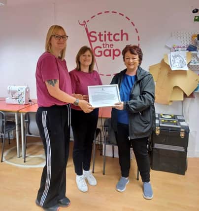 DELIGHTED: Amanda and Patricia, founders of Stitch the Gap, receive a framed motion from Rona Mackay MSP after their success at the EDGE Awards
