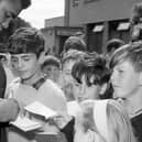 Boxer Muhammad Ali signs autographs for children on his arrival in Glasgow in 1965.