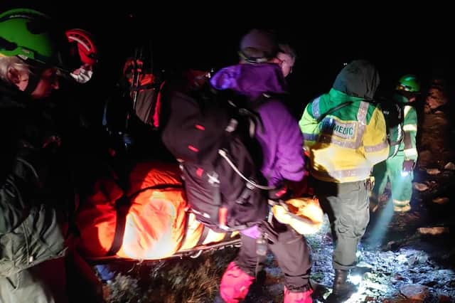 Parademics and the mountain rescue team carry the injured woman. Pic: Moffat MRT