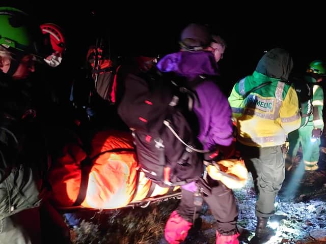 Parademics and the mountain rescue team carry the injured woman. Pic: Moffat MRT