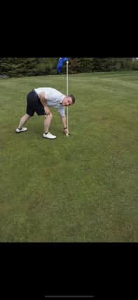 Mark Cairnie picks his ball out after hole in one