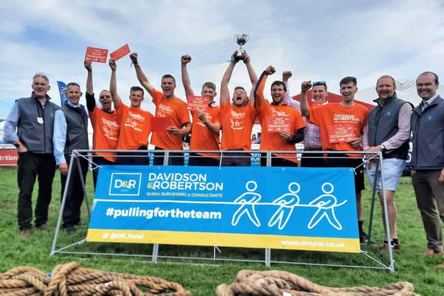 Jubilant male Carluke Young Farmers tug of war aces