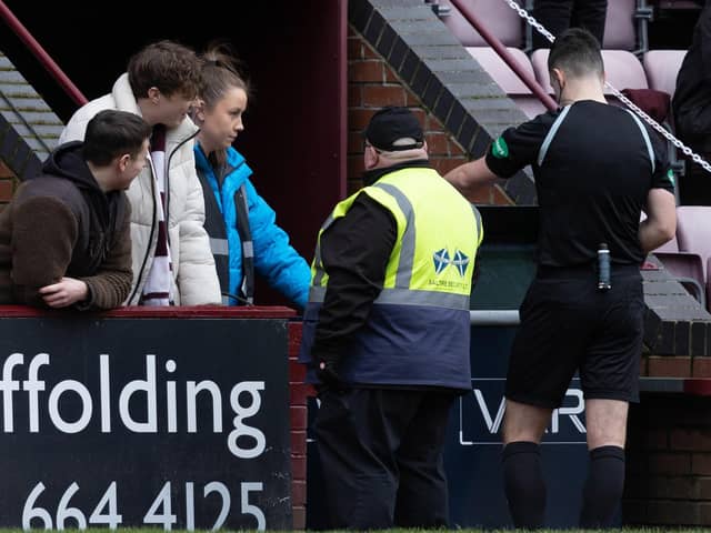 Referee Don Robertson checks the VAR monitor for a handball by Celtic's Tomoki Iwata.